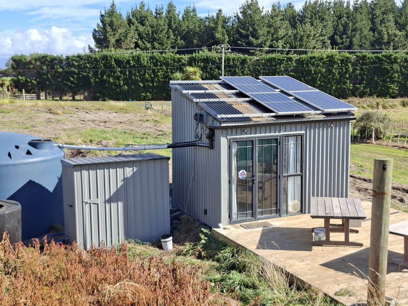 Exterior repaint by Holmes Decorating: a cabin with solar panels on a rural Manawatu property